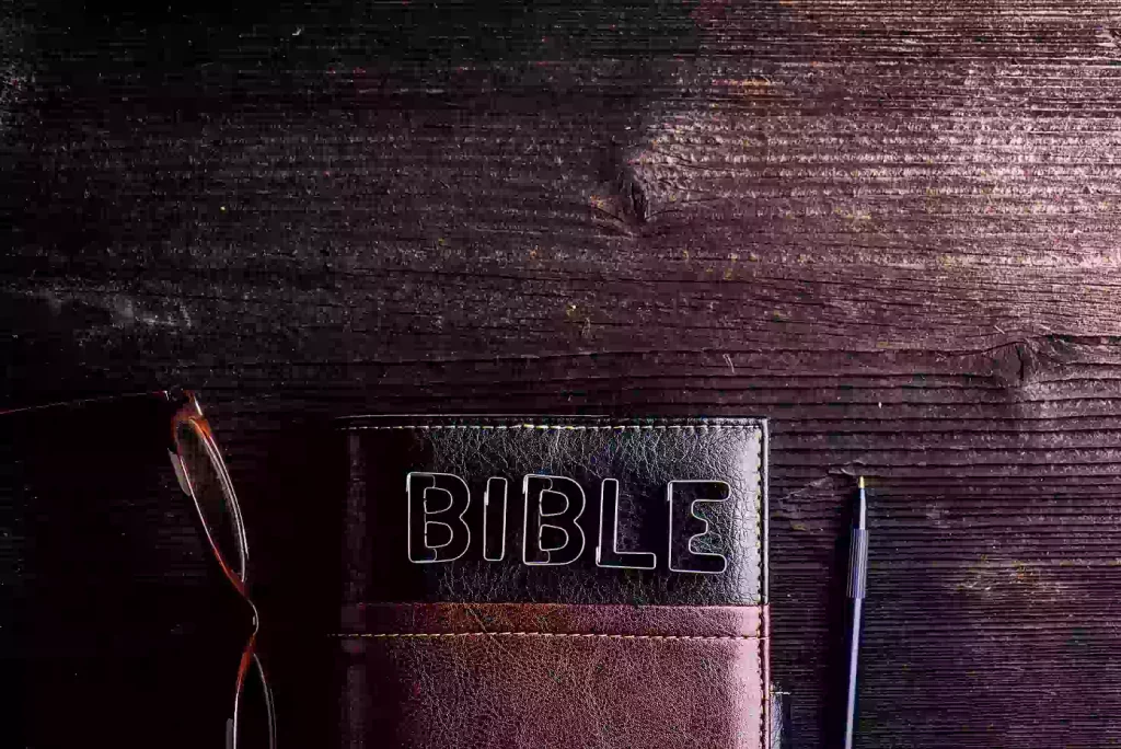 bible eyeglasses and pen laid on old wooden table sign made of cookie cutters