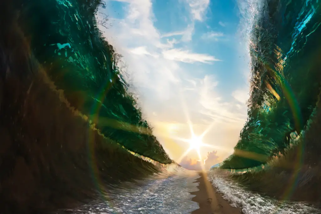 Big waves. Sea parted by a sandy path to the sun with footsteps print on sand